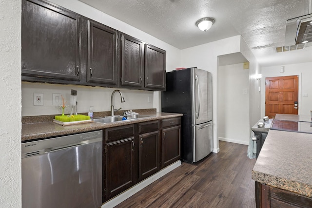 kitchen featuring dark brown cabinetry, sink, dark hardwood / wood-style floors, and appliances with stainless steel finishes