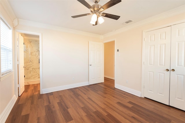 unfurnished bedroom featuring a closet, crown molding, dark hardwood / wood-style floors, and ensuite bathroom