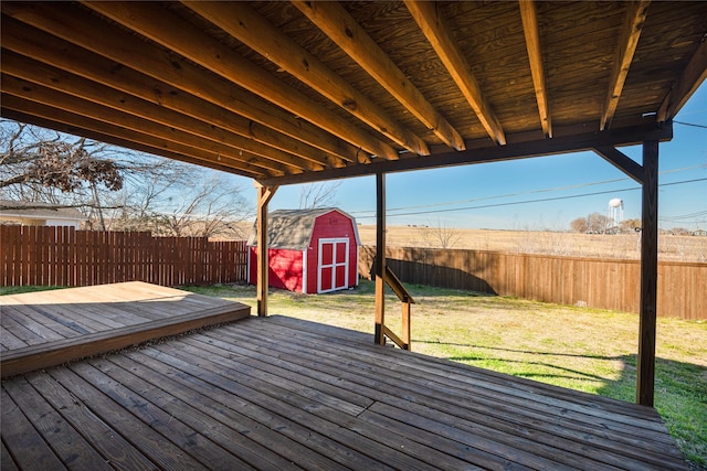 deck with a shed and a lawn