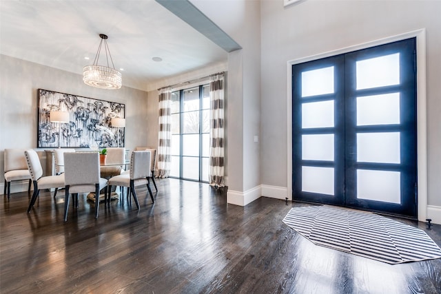 dining area with dark wood-type flooring and a notable chandelier