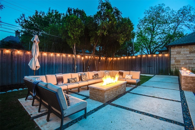 patio terrace at dusk with an outdoor living space with a fire pit