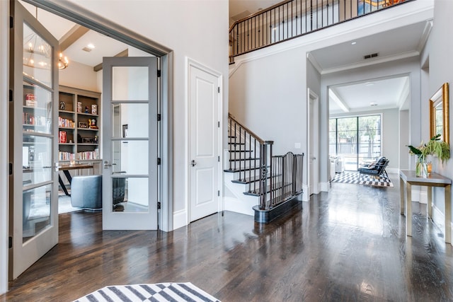 foyer entrance with crown molding, dark hardwood / wood-style floors, french doors, and a high ceiling