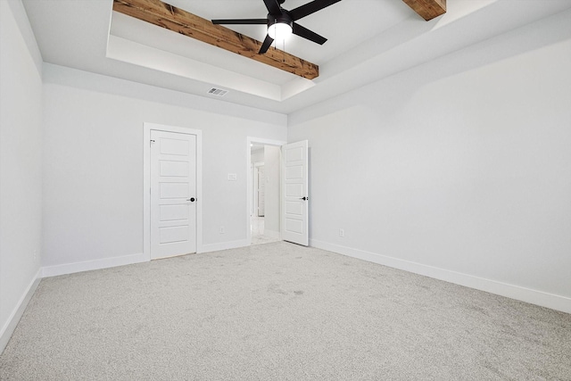 carpeted empty room featuring ceiling fan and beamed ceiling