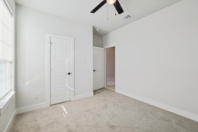 unfurnished bedroom featuring light colored carpet and ceiling fan