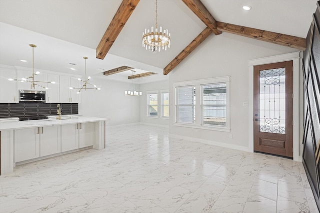 interior space featuring hanging light fixtures, white cabinets, and a chandelier