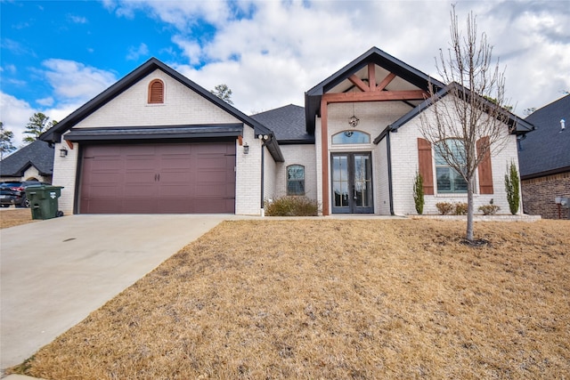 view of front of property with a garage, a front lawn, and french doors