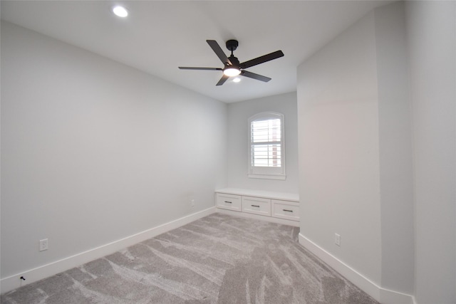 spare room featuring light carpet and ceiling fan