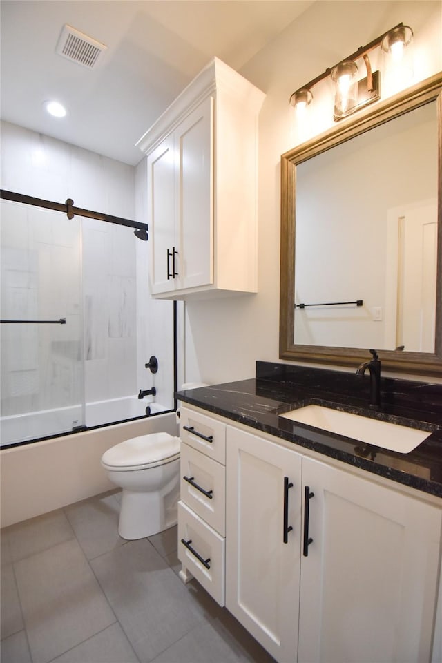 full bathroom with vanity, bath / shower combo with glass door, tile patterned floors, and toilet