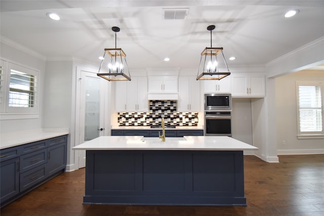 kitchen with a center island with sink, white cabinetry, appliances with stainless steel finishes, and pendant lighting