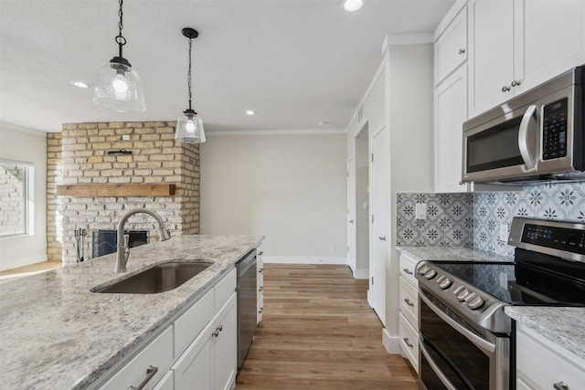 kitchen with a sink, crown molding, backsplash, and stainless steel appliances