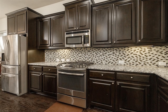 kitchen featuring dark hardwood / wood-style flooring, decorative backsplash, dark brown cabinetry, and appliances with stainless steel finishes