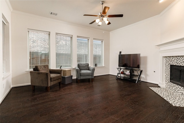 sitting room featuring ornamental molding, dark wood-type flooring, ceiling fan, and a fireplace