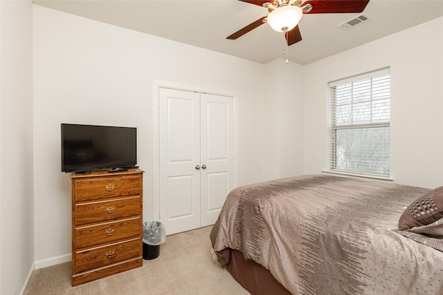 bedroom featuring light carpet, a closet, and ceiling fan