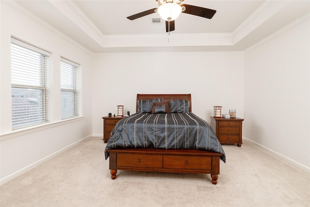 carpeted bedroom with crown molding, ceiling fan, and a raised ceiling