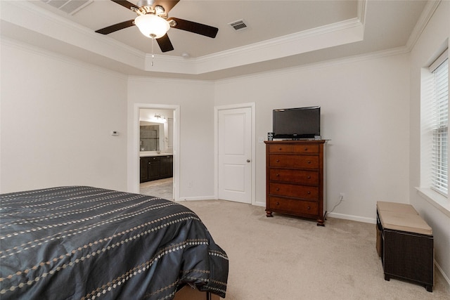 bedroom featuring connected bathroom, ceiling fan, a raised ceiling, crown molding, and light carpet