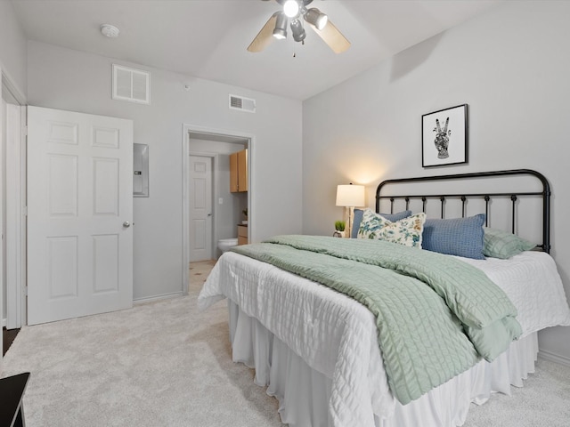 carpeted bedroom with ceiling fan, ensuite bathroom, and electric panel