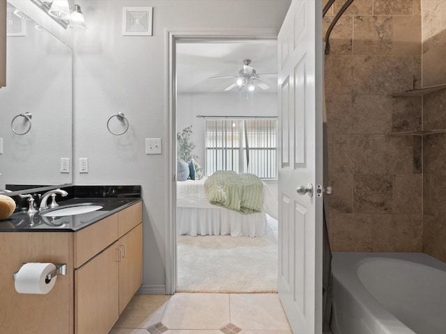 bathroom featuring ceiling fan, vanity, tiled shower / bath, and tile patterned flooring