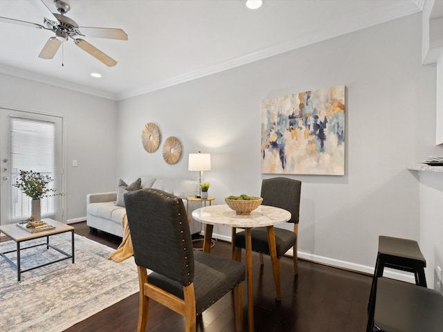 dining room with dark hardwood / wood-style flooring, crown molding, and ceiling fan