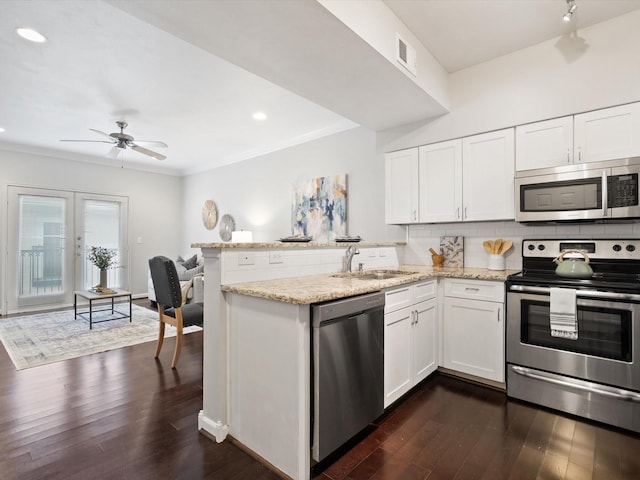 kitchen with white cabinetry, stainless steel appliances, kitchen peninsula, and sink