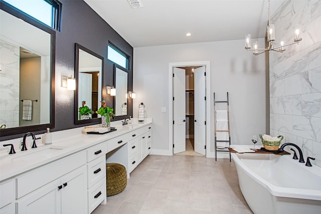 bathroom with vanity, a bathtub, and a notable chandelier