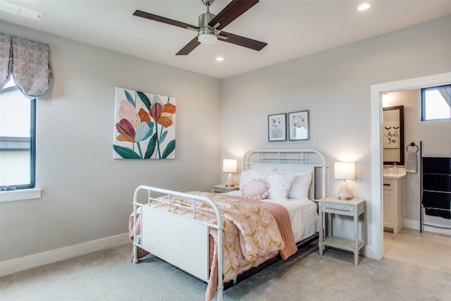 bedroom with ceiling fan, connected bathroom, and light carpet