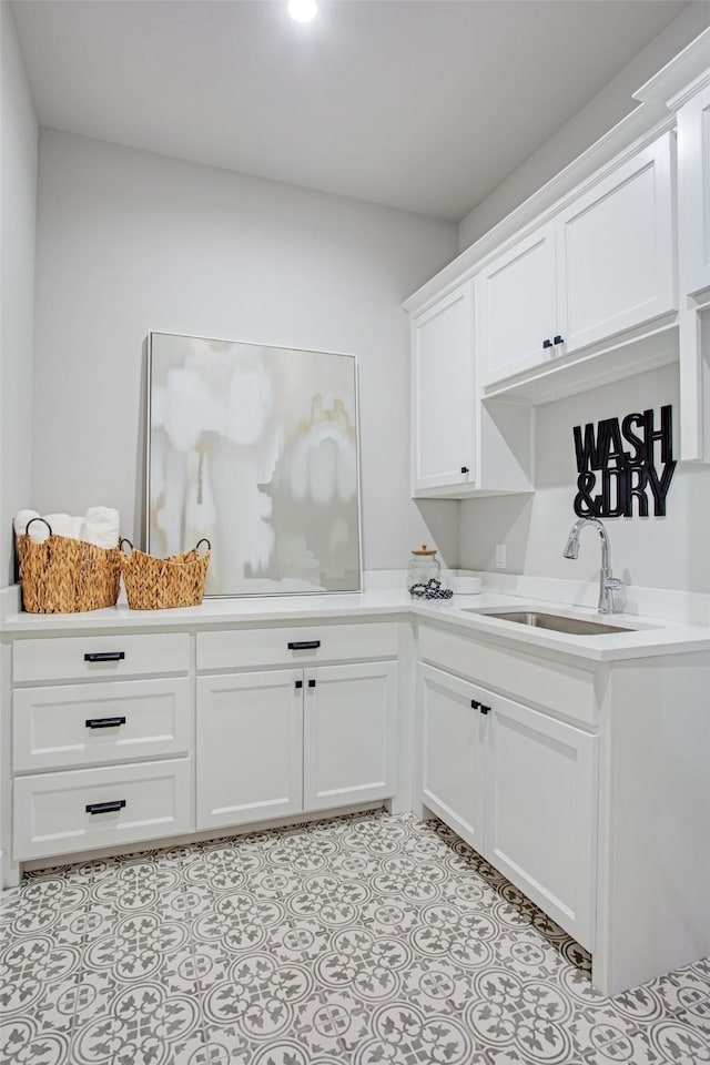 clothes washing area featuring sink and light tile patterned floors