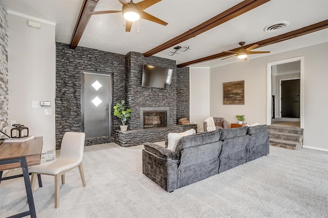 living room featuring beamed ceiling, ceiling fan, light colored carpet, and a fireplace