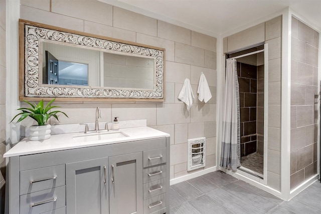 bathroom featuring vanity, heating unit, tile walls, and a shower with shower curtain