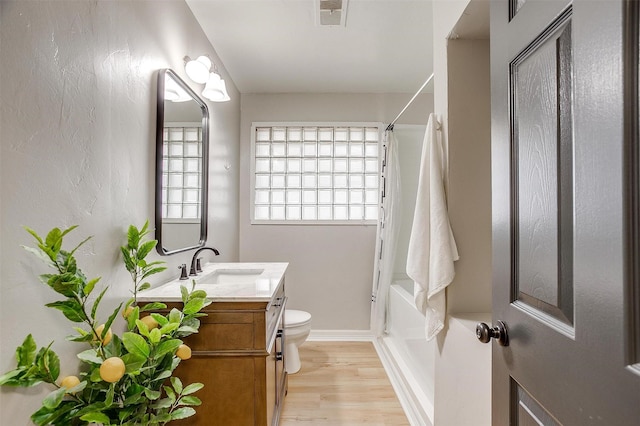 full bathroom featuring vanity, hardwood / wood-style floors, shower / tub combination, and toilet