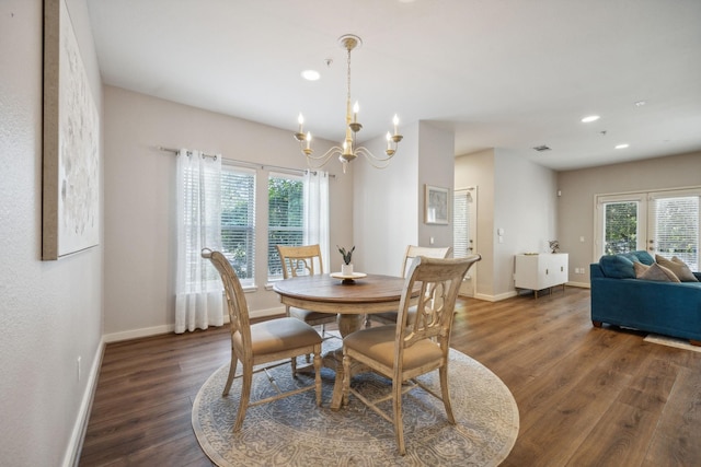 dining space featuring dark wood-type flooring and a chandelier