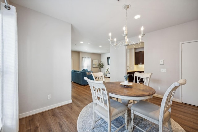 dining space with hardwood / wood-style flooring and a chandelier