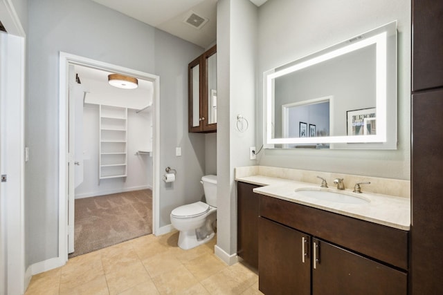 bathroom featuring vanity, tile patterned flooring, and toilet