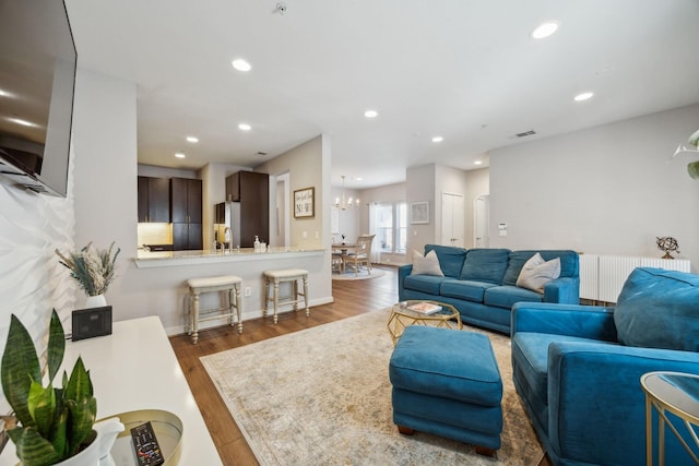 living room with dark hardwood / wood-style floors and a chandelier