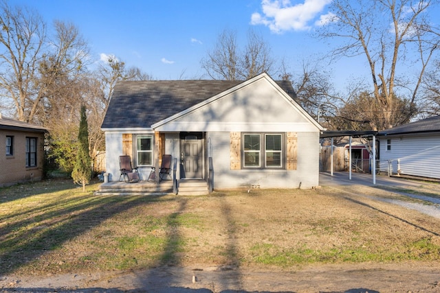 view of front of property with a carport and a front lawn