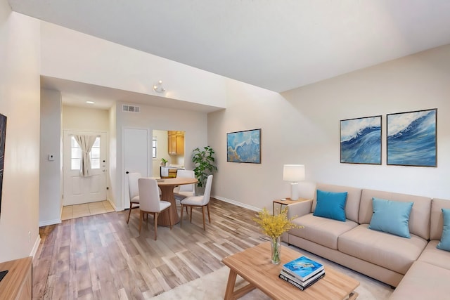 living room featuring vaulted ceiling and light hardwood / wood-style flooring