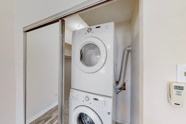 washroom featuring stacked washer and clothes dryer