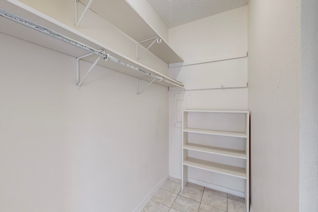 walk in closet with light tile patterned floors