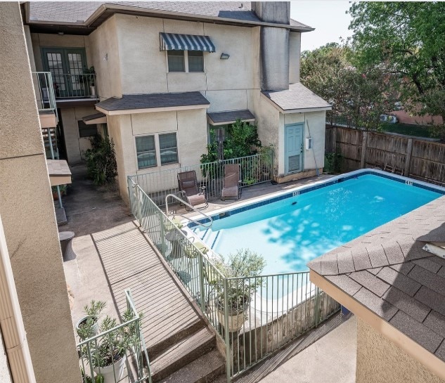 view of swimming pool featuring a patio area, a fenced in pool, fence, and french doors