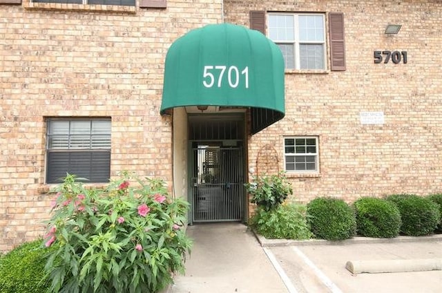 doorway to property with brick siding