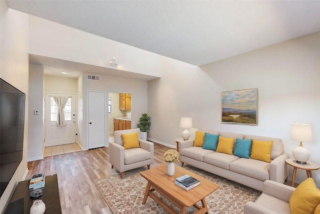 living room with lofted ceiling and light hardwood / wood-style flooring