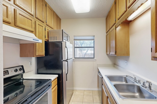 kitchen featuring appliances with stainless steel finishes, sink, a textured ceiling, and light tile patterned floors