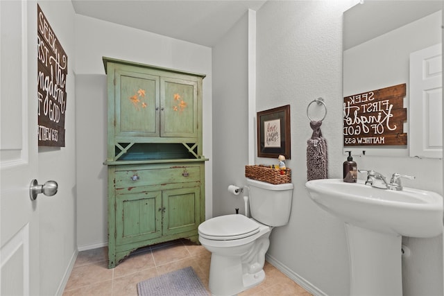 bathroom featuring sink, toilet, and tile patterned flooring