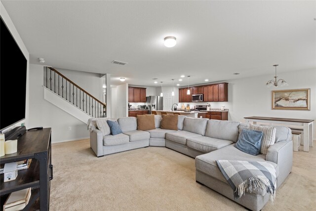 living room featuring light carpet, a notable chandelier, and sink