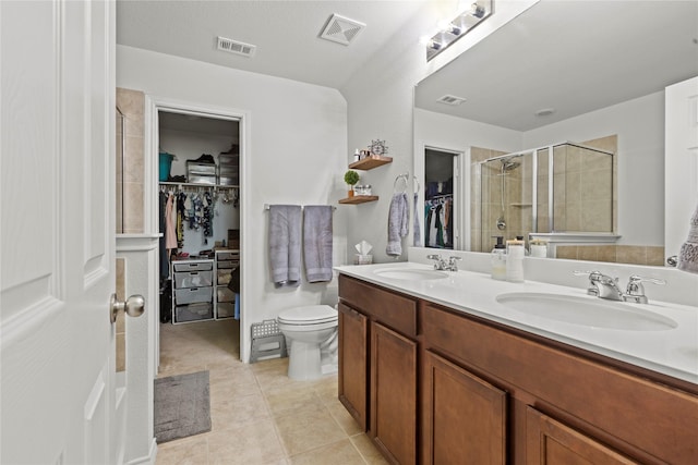 bathroom featuring tile patterned flooring, vanity, a shower with door, and toilet