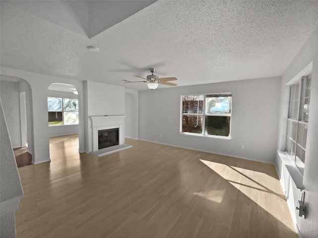 unfurnished living room with hardwood / wood-style floors, a textured ceiling, and ceiling fan