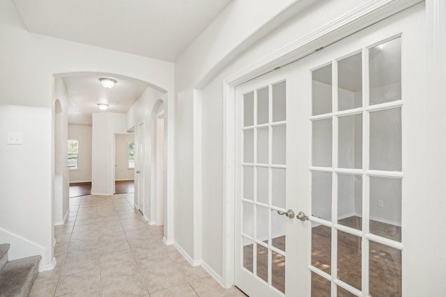 hall featuring french doors and light tile patterned flooring