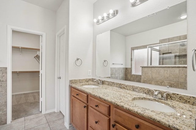 bathroom featuring tile patterned flooring, vanity, and walk in shower