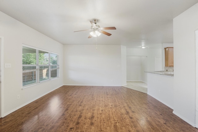 empty room with dark wood-type flooring and ceiling fan