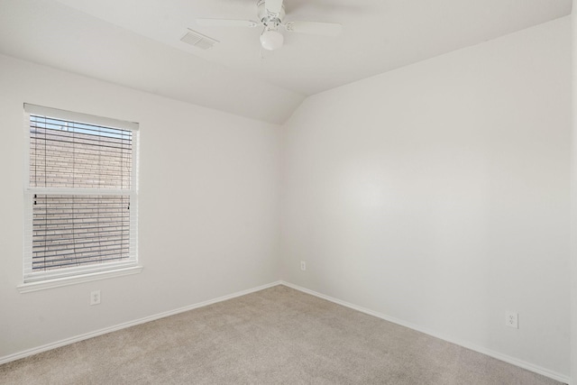 spare room with light carpet, vaulted ceiling, and ceiling fan