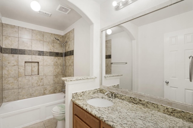 full bathroom with tiled shower / bath, vanity, toilet, and tile patterned floors